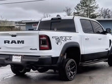 Load image into Gallery viewer, White RAM TRX pickup truck with custom bedside decal featuring TRX logo and T-Rex graphic, parked in a residential area on a cloudy day