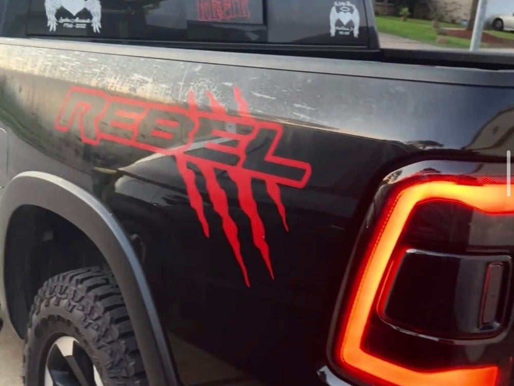 Black RAM Rebel truck with stylish reflective red claw mark logo bedside graphics