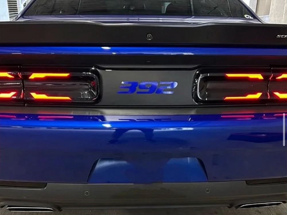 Dodge Challenger rear view with blue 392 logo on black taillight divider, showcasing customizable decal between illuminated taillights on vibrant blue body