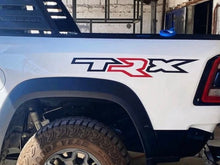 Load image into Gallery viewer, RAM TRX bedside decal on white truck, featuring black &#39;T&#39; and &#39;X&#39; letters with a red &#39;R&#39; in the middle, positioned above the rear wheel well, showcasing custom vinyl design for truck customization