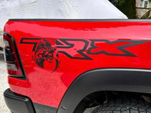 Load image into Gallery viewer, RAM TRX bedside decal on a bright red truck, featuring the TRX logo and a T-Rex dinosaur head emblem. The decal is black, contrasting sharply with the vibrant red paint of the truck&#39;s body.