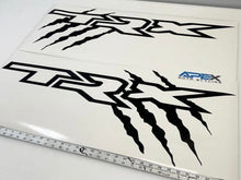 Load image into Gallery viewer, RAM TRX bedside decals with claw marks, displayed on white background with measuring tape. Top decal shows TRX logo, bottom decal includes Apex logo and claw marks. OEM size and custom design for truck customization.