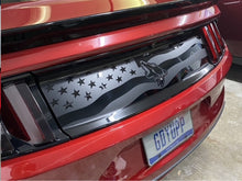 Load image into Gallery viewer, Red Ford Mustang rear decklid with American flag and Coyote logo decal installed, showcasing custom vinyl design on glossy surface between taillights