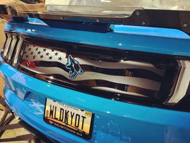 Blue Ford Mustang rear decklid with American flag decal and coyote logo, showcasing custom S550 decklid design for 2015-2023 models. License plate visible reading 