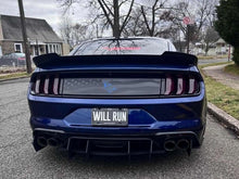 Load image into Gallery viewer, Rear view of blue Ford Mustang S550 with American flag decklid decal and Coyote logo, showcasing custom license plate &quot;WILL RUN&quot; and quad exhaust tips on suburban street