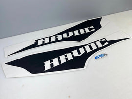 Two black and white RAM TRX Havoc Edition bedside decals with angular design, displaying HAVOC text, alongside a small blue squeegee tool for installation