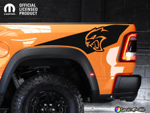 Load image into Gallery viewer, Orange RAM TRX truck with black Hellcat logo decal on bedside, showcasing custom Ignition Style graphics. Official licensed product by Mopar, displaying rugged off-road tires and sleek design against dark background.