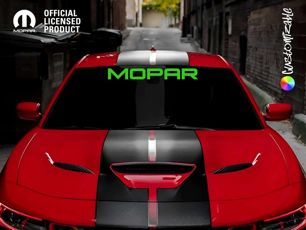 Red Jeep Grand Cherokee with black racing stripes and bright green MOPAR logo on windshield banner, parked in urban alley. Official licensed product logo visible in corner.