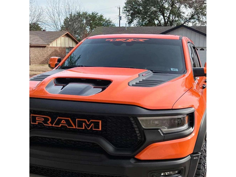 Orange RAM truck with TRX logo windshield banner decal, showcasing custom vinyl application on rear sliding window for a unique and stylish appearance