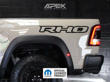 Load image into Gallery viewer, Ram RHO bedside decal on white truck, showcasing Apex Auto Styling branding and Mopar official licensed product logo, with visible rear taillight and wheel well