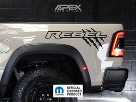 RAM Rebel truck bedside featuring custom decal with 'REBEL' text and claw mark design, showcasing rugged styling and personalization options for the vehicle's exterior