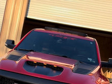 Load image into Gallery viewer, Red truck with TRX logo windshield banner decal visible on tinted rear window, parked in front of wooden garage door, showcasing custom vinyl application and premium fit