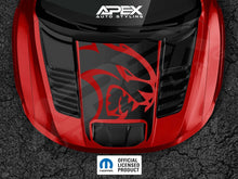 Load image into Gallery viewer, Red RAM TRX truck hood with large black cutout featuring red Hellcat logo decal, showcasing Apex Auto Styling product on glossy surface with air vents and official licensed product badge