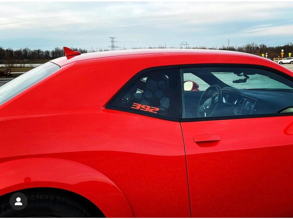 Red Dodge Challenger with custom 392 logo decal on quarter window, showcasing sleek design and performance-inspired styling against a cloudy sky backdrop