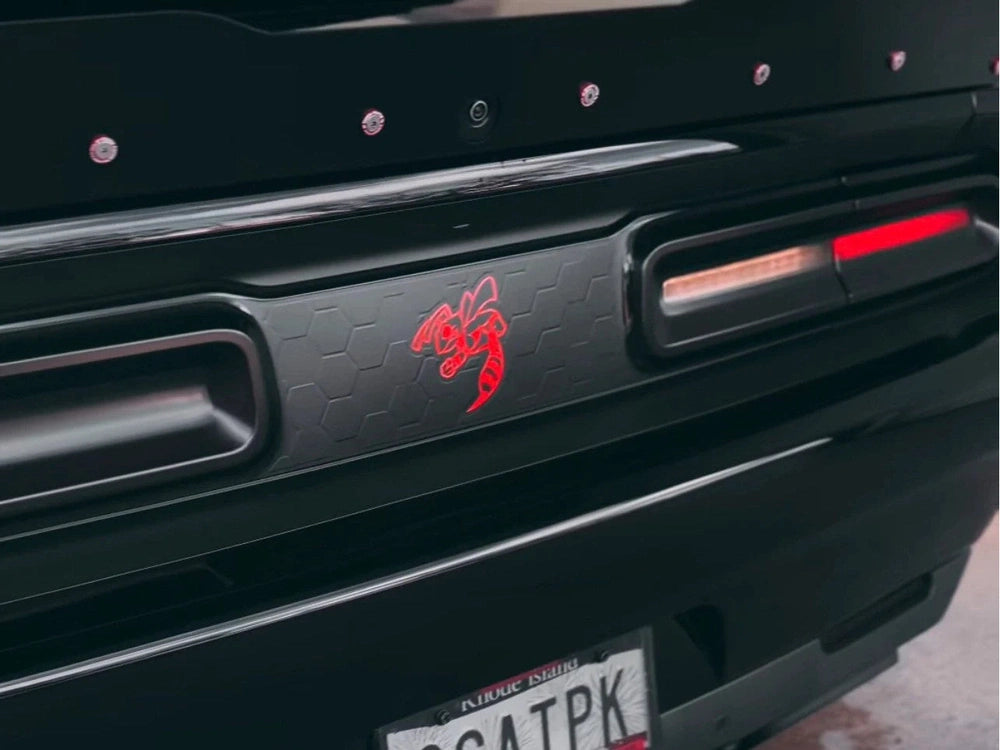 Closeup of black Dodge Challenger taillight divider with red Angry Hornet logo decal, showcasing customizable design and precise fit between taillights