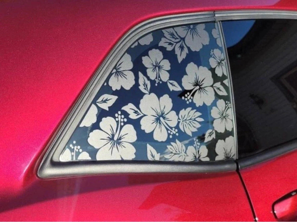 Dodge Challenger quarter window with floral pattern decal featuring white hibiscus flowers on blue background, showcased on a red car body