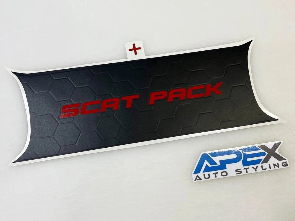 Challenger taillight divider decal with "SCAT PACK" text in red on black hexagonal pattern background. Apex Auto Styling logo in blue and white below. White curved edges and small red cross detail.
