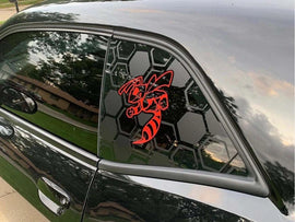 Dodge Challenger quarter window with custom red angry hornet logo decal on black hexagonal background, showcasing unique vinyl design for car customization