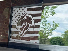 Load image into Gallery viewer, Custom RAM truck rear sliding window decal featuring American flag with TRX dinosaur logo, displayed on vehicle with outdoor reflection visible
