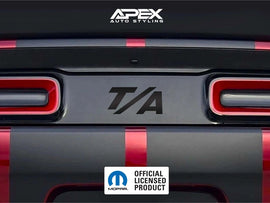 Dodge Challenger taillight divider with T/A logo decal, showcasing customizable design options for enhanced rear appearance. Black decal with raised pattern visible between red taillights on gray vehicle body.