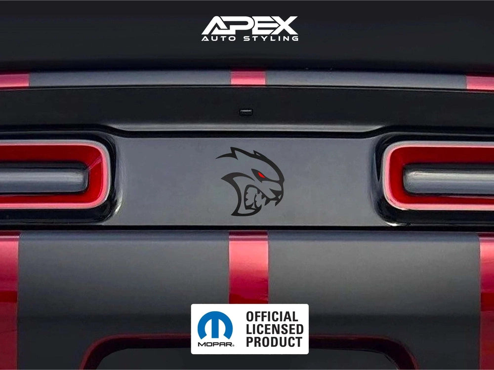 Challenger taillight divider decal with Hellcat Redeye logo, featuring matte black background and stylized cat head design with red eye, positioned between red taillights on gray and red striped rear bumper