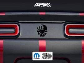 Dodge Challenger taillight divider with black MOPAR skull logo decal, showcasing customizable design options for car enthusiasts. Red taillights and rear bumper visible.