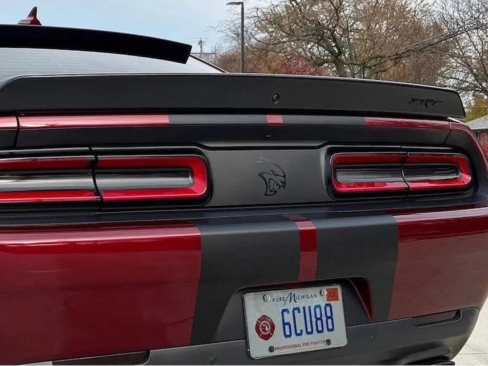 Customized Dodge Challenger rear view featuring taillight divider decal with Hellcat logo, showcasing sleek design and personalized style on a red and black sports car exterior
