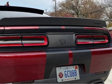 Load image into Gallery viewer, Customized Dodge Challenger rear view featuring taillight divider decal with Hellcat logo, showcasing sleek design and personalized style on a red and black sports car exterior