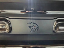 Load image into Gallery viewer, Dodge Challenger taillight divider with Hellcat Redeye logo decal applied, showcasing custom matte black design with embossed pattern and red-eyed cat emblem between taillights