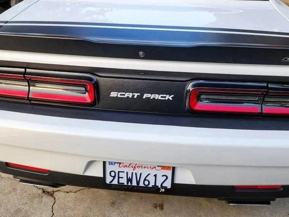 Dodge Challenger Scat Pack taillight divider with customizable decal, featuring sleek design and red taillights. White car body with California license plate visible.