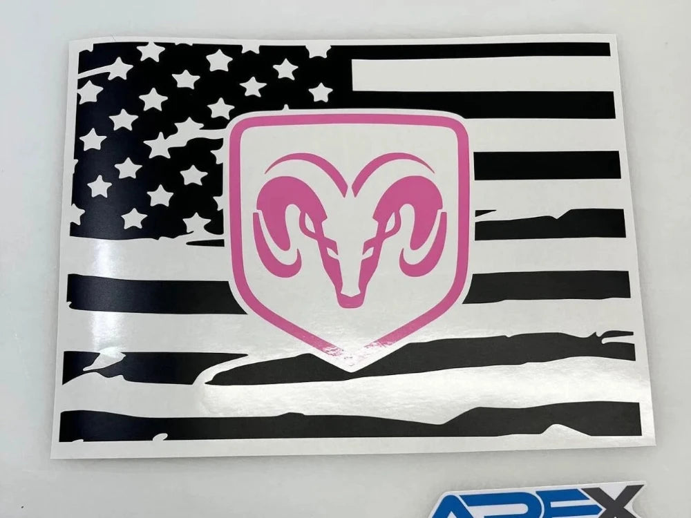 RAM logo decal on distressed American flag background for 2009+ RAM truck rear sliding window, featuring pink RAM head symbol on white shield against black and white flag design