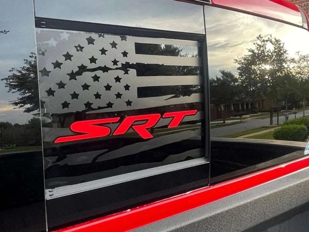 Custom RAM truck rear sliding window decal featuring American flag design with stars and stripes in matte black vinyl, and bold red SRT logo. Sunset backdrop visible through transparent window areas.