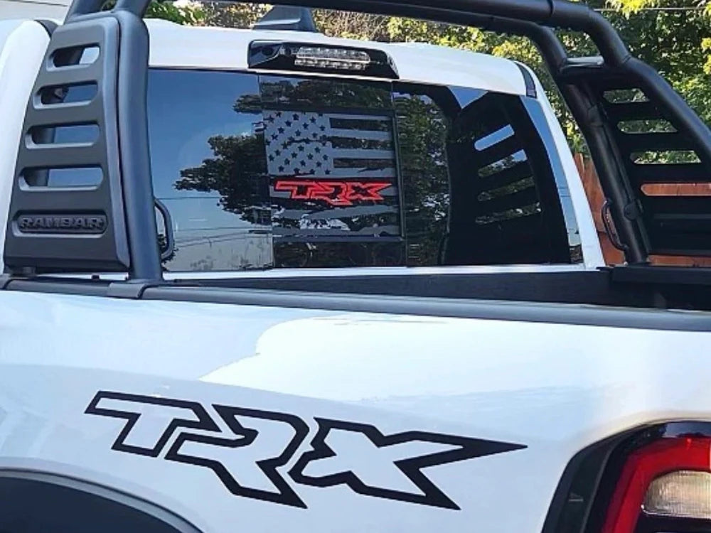 RAM truck rear sliding window with custom TRX logo decal featuring American flag design and red TRX branding, displayed on white pickup truck with matching TRX side decal