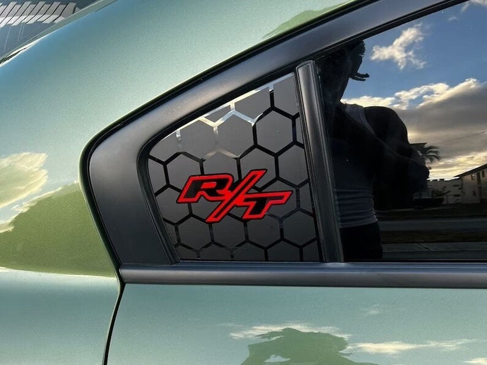 Dodge Charger quarter window decal with red R/T logo on black hexagon pattern, applied to green car exterior, reflecting cloudy sky