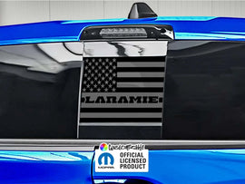 RAM truck rear sliding window with black American flag decal featuring Laramie logo, blue exterior, official licensed product sticker visible