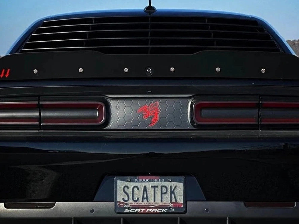 Dodge Challenger rear view with taillight divider decal featuring red Angry Hornet logo, custom license plate SCATPK, and distinctive taillights against a blue sky background