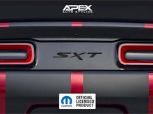Load image into Gallery viewer, Challenger taillight divider with SXT logo decal applied, showcasing custom design between red taillights on gray and red striped vehicle rear. APEX Auto Styling and Mopar logos visible.