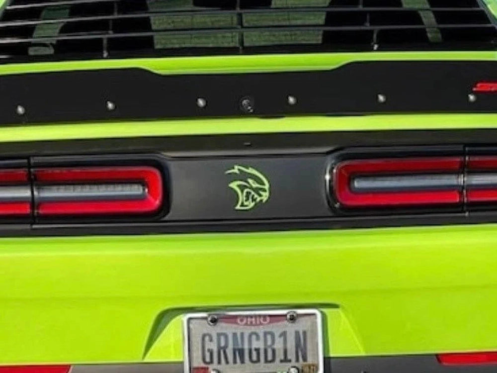 Bright green Dodge Challenger rear view showcasing taillight divider decal with Hellcat logo, red taillights, and Ohio license plate GRNGB1N