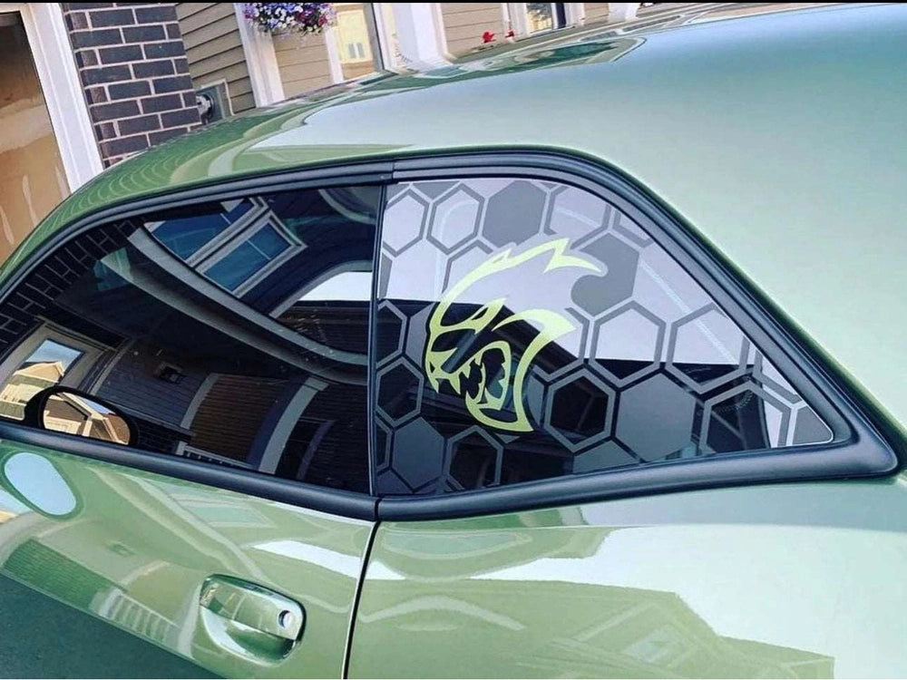 Green Dodge Challenger with custom Hellcat logo quarter window decal featuring honeycomb pattern and neon green cat head design, showcasing unique automotive styling and personalization