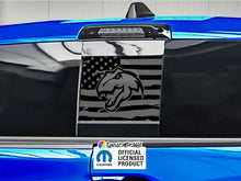 Load image into Gallery viewer, RAM truck rear sliding window with black TRX Dino logo decal on American flag background, showcased on blue vehicle exterior, with official licensed product tag visible