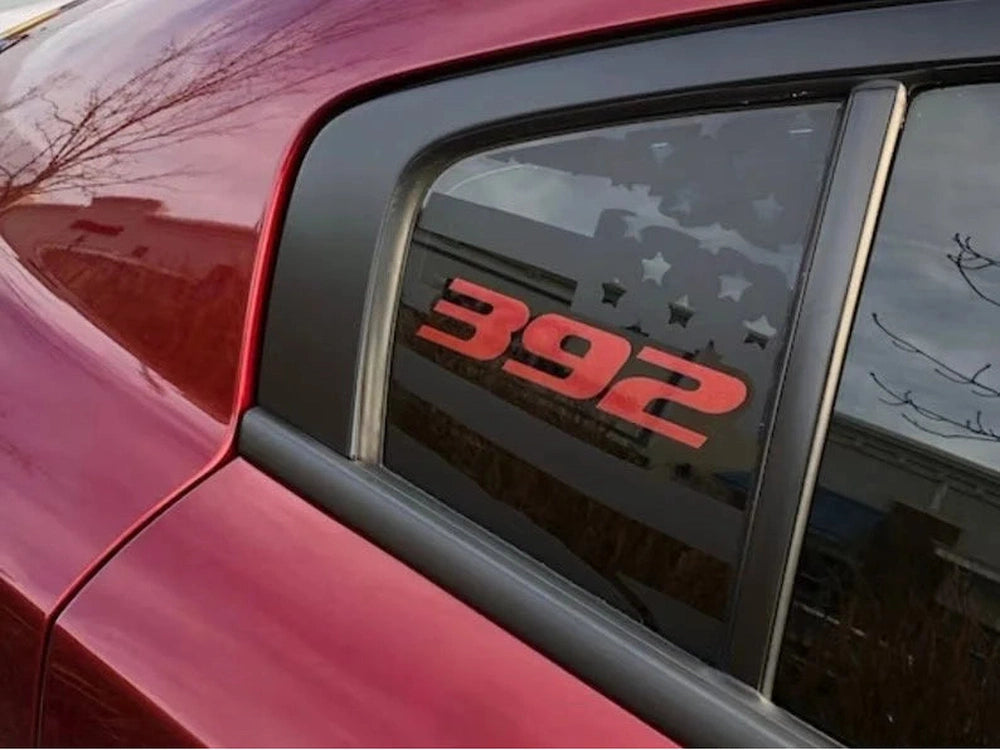 Close-up of a red Dodge Charger's quarter window featuring a custom 392 logo decal in red with stars, showcasing the sleek and sporty appearance of the vehicle's exterior design.