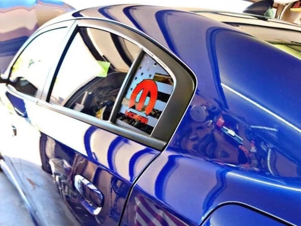Blue Dodge Charger with custom MOPAR logo quarter window decal in red, showcasing sleek design and personalized style for 2011-2023 models