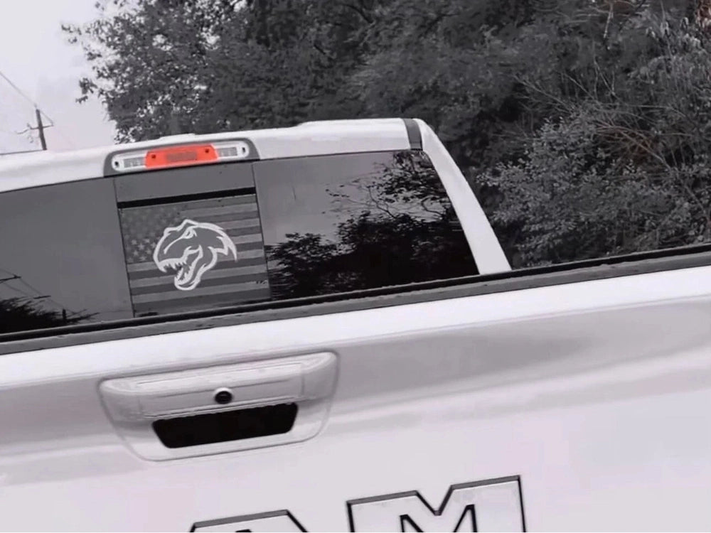 RAM truck with custom TRX Dino logo decal on rear sliding window, showcasing the product on a white pickup against a natural background