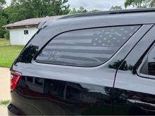 Load image into Gallery viewer, Dodge Durango quarter window decal featuring R/T logo and American flag design in matte black, applied to rear side window of dark-colored SUV parked in grassy area with trees in background