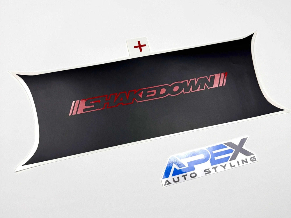 Challenger taillight divider decal with red "Shakedown" logo on black background, displayed alongside Apex Auto Styling logo. Custom vinyl accessory for enhancing vehicle appearance and protecting against scratches.