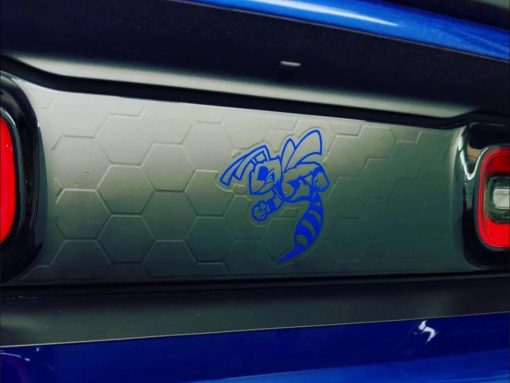 Dodge Challenger taillight divider with blue Angry Hornet logo decal on hexagonal pattern background, showcasing customizable vinyl design between red taillights and blue body paint