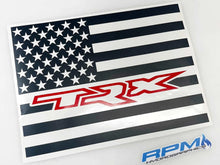 Load image into Gallery viewer, Custom RAM truck rear sliding window decal featuring black and white American flag design with red TRX logo, showcasing patriotic style and brand loyalty for 2009+ RAM pickup owners