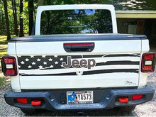Load image into Gallery viewer, White Jeep Gladiator tailgate with American flag-inspired decal featuring stars, stripes, and Jeep logo, parked in a wooded area. Custom vinyl design showcases patriotic style on truck&#39;s rear.