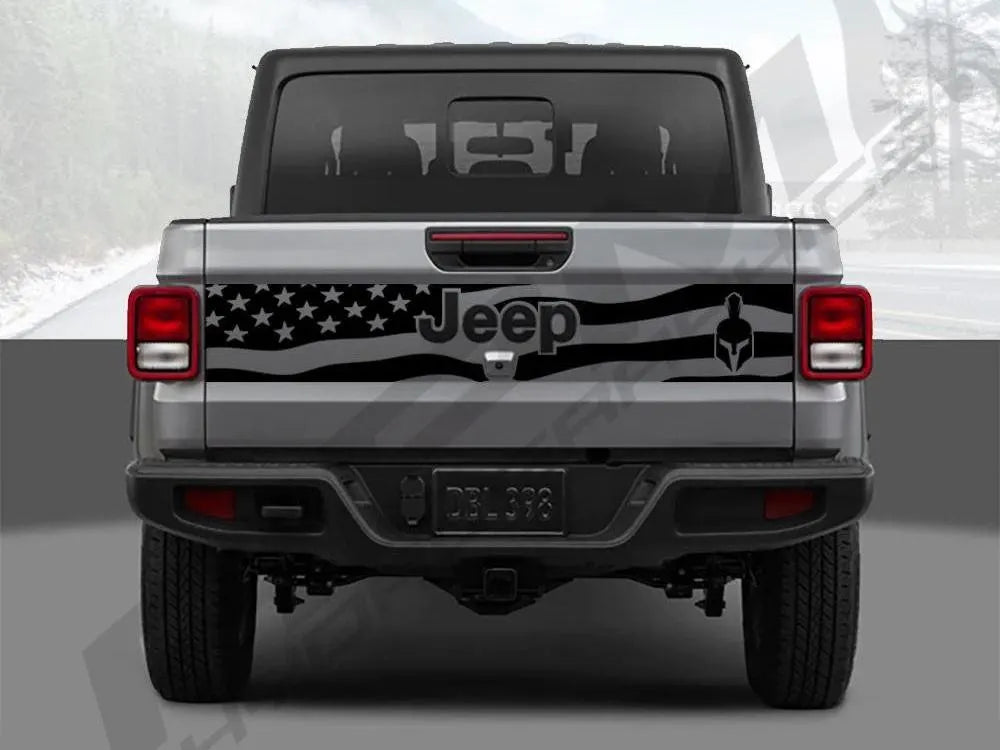 Rear view of a silver 2020+ Jeep Gladiator pickup truck with a black tailgate decal featuring an American flag design, Jeep logo, and Gladiator emblem, showcasing the custom vinyl accessory for the vehicle's tailgate.