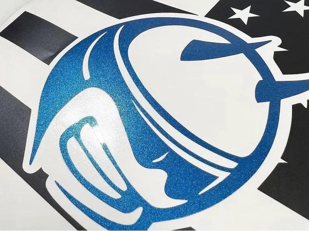 Closeup of blue Demon Bee logo decal for Dodge Charger quarter window, featuring stylized bee design with metallic sheen against black and white striped background with stars